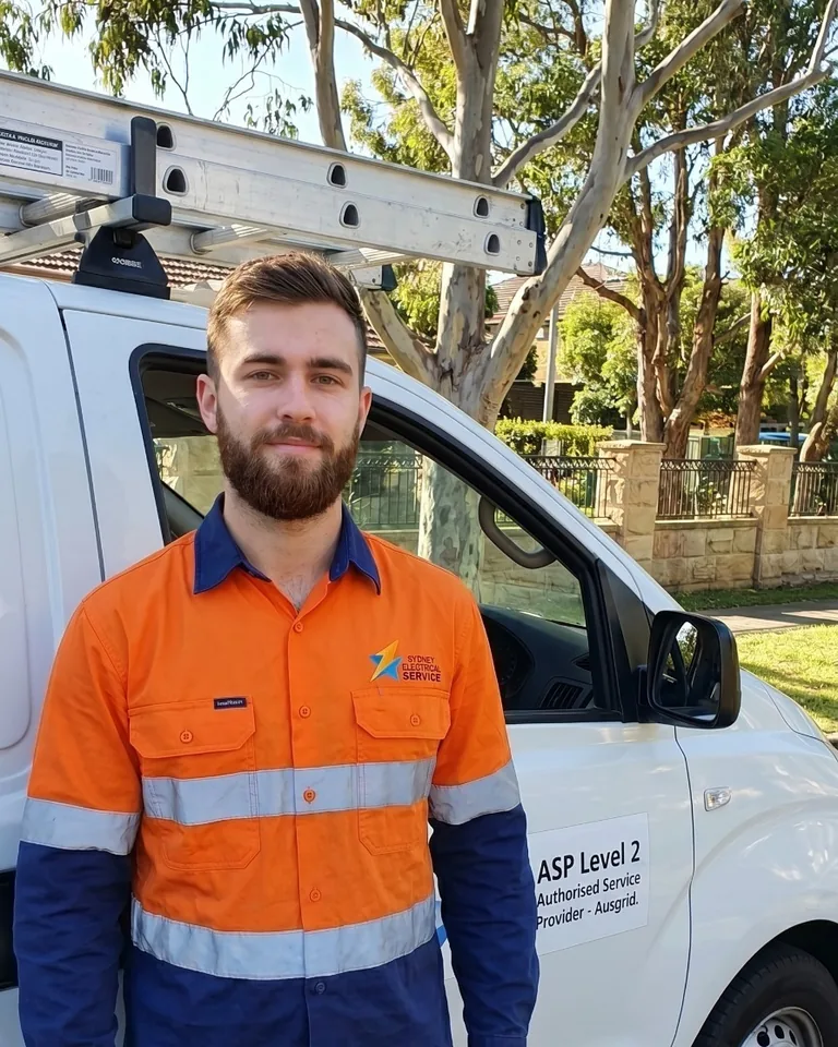 Sydney Electrical Service Level 2 electrician in branded hi-vis beside a company van